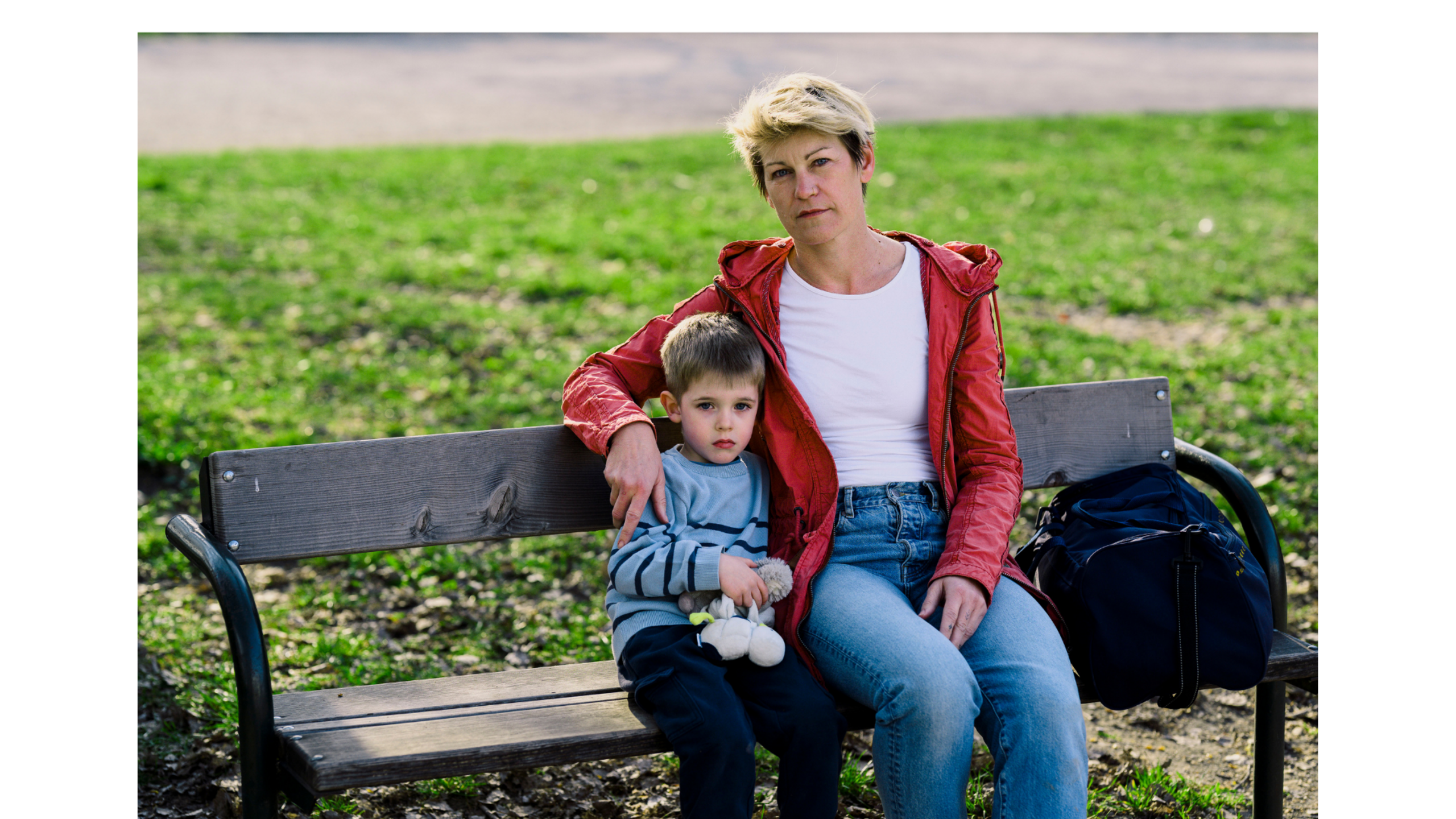 Eine Frau und ein Kind sitzen auf einer Parkbank.