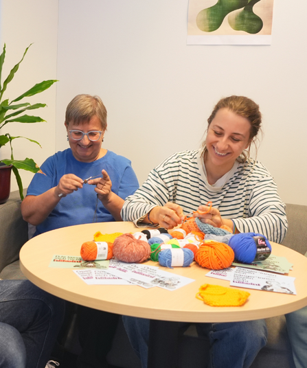 Vier Personen häkeln gemeinsam.